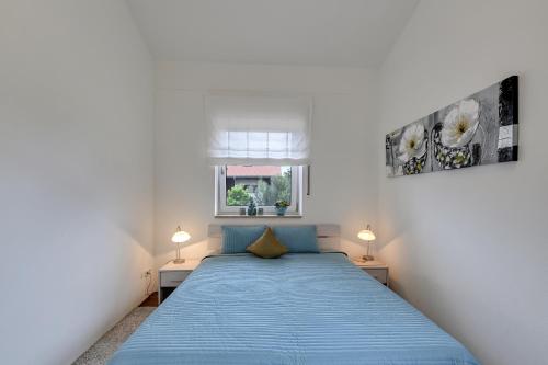 a bedroom with a blue bed and two lamps at Ferienwohnung Panorama Og in Inzell