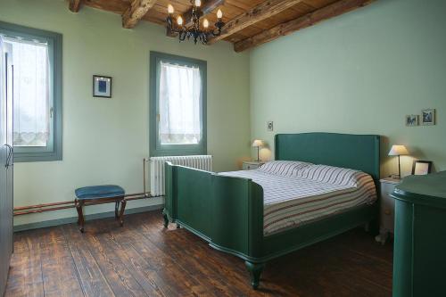 1 dormitorio con 1 cama verde y 2 ventanas en B&B Carlonga, en Caneva