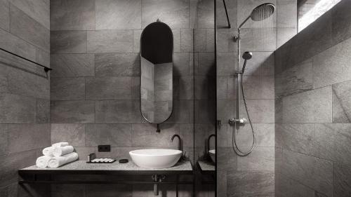 ein Bad mit einem Waschbecken und einer Dusche in der Unterkunft GOOD ZONE Hotel in Peschanka