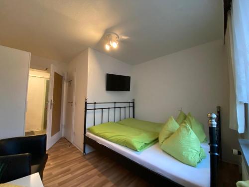 a bedroom with a bed with green pillows on it at Pension Glückauf in Kurort Oberwiesenthal