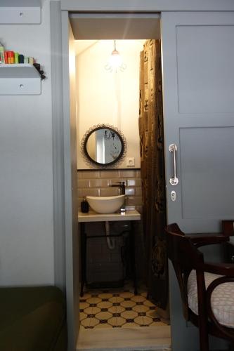 a bathroom with a sink and a mirror at Tilas - Rooms in 19th Century Wooden Townhouse,Kadikoy in Istanbul