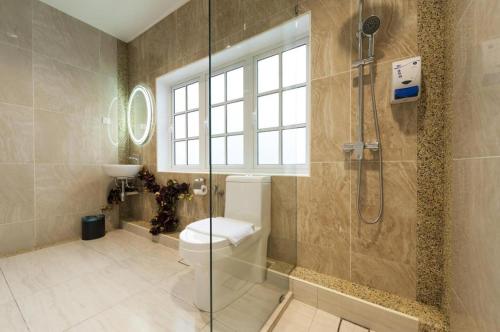 La salle de bains est pourvue de toilettes et d'une douche en verre. dans l'établissement Seriental Hotel, à Tanjong Tokong