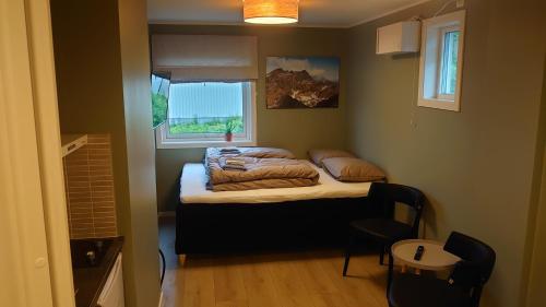 um pequeno quarto com uma cama e uma janela em På Hjørnet Gjestehus em Skjervøy
