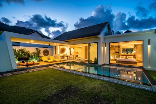 a villa with a swimming pool at night at Cocoon Villa - Peaceful private pool villa in north Phuket in Phuket