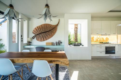 a kitchen and dining room with a wooden table and chairs at Cocoon Villa - Peaceful private pool villa in north Phuket in Phuket