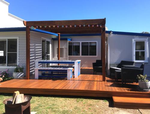 a wooden deck with a bench on top of it at SHELLHARBOUR BEACH COTTAGE - Stroll to Beach flags - Back gate straight to Beach, Front gate walk to new Marina in Shellharbour