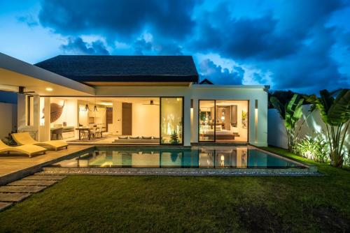 a villa with a swimming pool at night at Cocoon Villa - Peaceful private pool villa in north Phuket in Phuket
