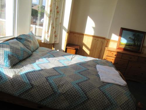 a bedroom with a bed and a dresser and a television at Lennard House in Folkestone