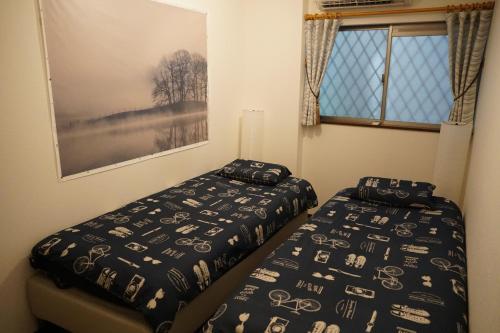 A bed or beds in a room at Auberge du Tanuki Noir Maison d'Hôtes