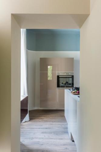 a kitchen with white cabinets and a blue ceiling at San Leonardo Suites in Verona