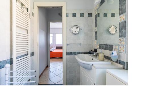 a bathroom with a white sink and a tub at ENJOY VARENNA CASA VACANZE in Varenna