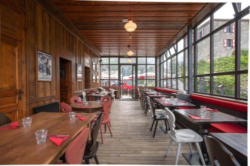 a restaurant with wooden tables and chairs and windows at Refuge du Montenvers in Chamonix-Mont-Blanc