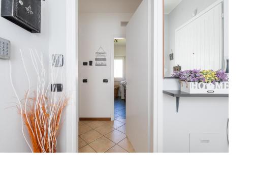 a hallway with white walls and a hallway with flowers at ENJOY VARENNA CASA VACANZE in Varenna