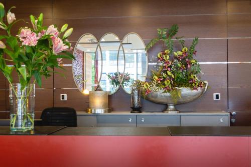 Hotel Stadt Kufstein في كوفشتاين: كونتر به مزهريتين كبيرتين مع الزهور عليه