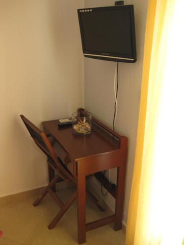 a table with a television on a wall with a chair at Meltemi in Vourkarion