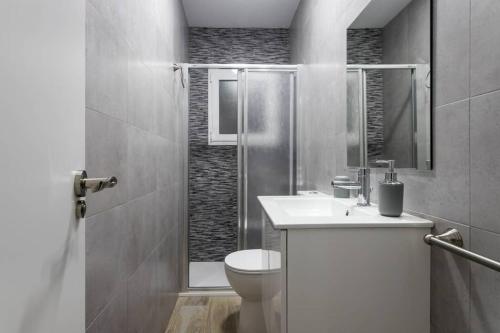 a bathroom with a toilet and a sink and a shower at Espacioso y céntrico piso con zona chill-out in Alicante