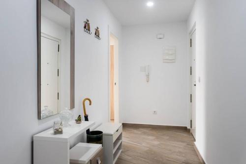 ein weißes Badezimmer mit Waschbecken und Spiegel in der Unterkunft Espacioso y céntrico piso con zona chill-out in Alicante