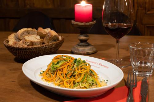 a plate of food on a table with a candle and a glass of wine at Refuge du Montenvers in Chamonix-Mont-Blanc