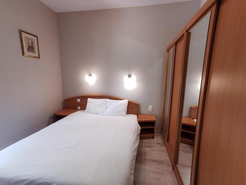 a bedroom with a white bed and a mirror at Wysokie Horyzonty in Karpacz