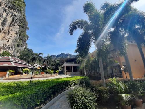 a building with palm trees in front of it at Diamond Cave Resort in Railay Beach