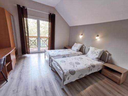 a bedroom with two beds and a large window at Wysokie Horyzonty in Karpacz