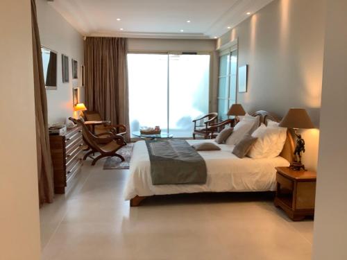 a bedroom with a large bed and a large window at Chambre à louer au coeur d'Arcachon in Arcachon