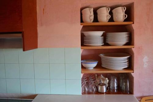 a shelf with plates and dishes on it in a kitchen at Rectoría de Castellar in La Vall de Bianya