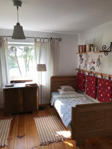 a bedroom with a bed and a desk and a window at Dom Wakacyjny - Siedlisko Gutowo in Lidzbark