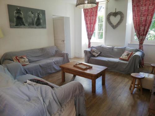 a living room with two couches and a table at Le domaine des 3 marmottes Chambres d' hôtes in Cierp