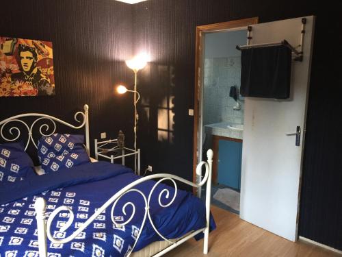 una camera da letto con un letto con lenzuola blu e un lavandino di Maison calme a Beaumes-de-Venise