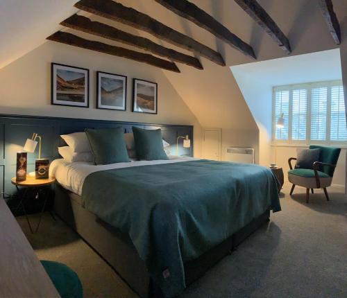 a bedroom with a large bed and a chair at The Balerno Inn in Edinburgh