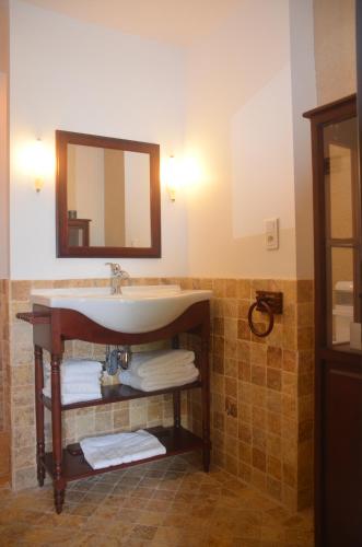 a bathroom with a sink and a mirror and towels at L'ère du temps in Cuzance