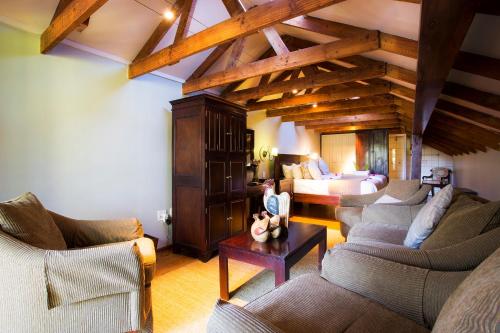 a living room with two couches and a bed at Tamboti Lodge Guest House in Tzaneen