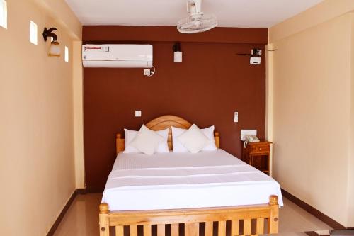 a bedroom with a large bed with white sheets at Bluewater Beach Resort in Trincomalee