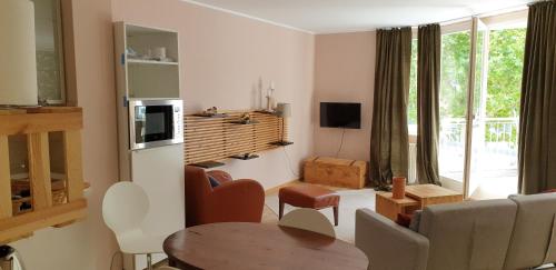 ein Wohnzimmer mit einem Tisch und ein Wohnzimmer mit einem TV in der Unterkunft Bacchus - helles und geräumiges Appartement am Rande von Mainz in Mainz