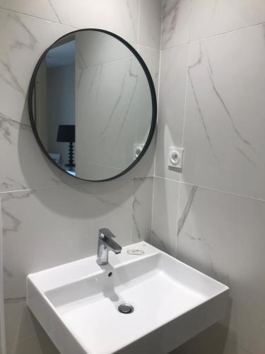 a white bathroom with a sink and a mirror at L'Acqua Viva in Calacuccia