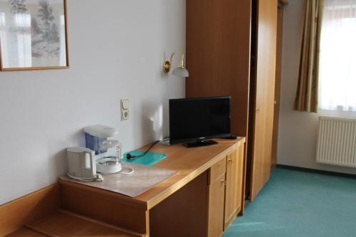 a room with a desk with a television on it at Hotel garni Vogelsang in Bad Füssing
