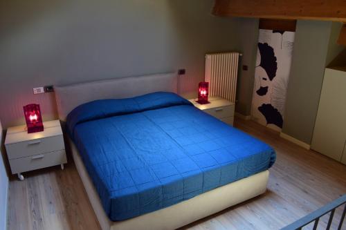 um quarto com uma cama azul e duas mesas de cabeceira em Borghetto Country Apartments em Saludecio