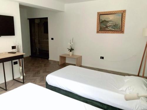 a bedroom with two beds and a picture on the wall at Hotel Lido in Durrës