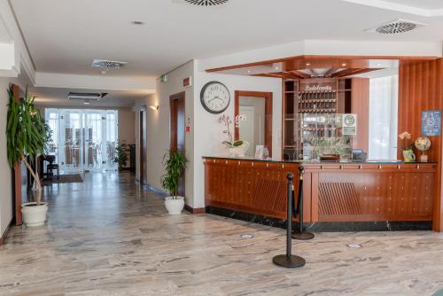 eine Lobby mit einer Theke und einer Uhr an der Wand in der Unterkunft Hotel Audi Frontemare in Rimini