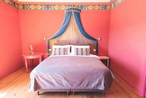a bedroom with a king sized bed with red walls at Poppi Suites in Poppi