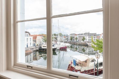 an open window with a view of a marina at HARBOR HOUSE ZEELAND - nl in Goes