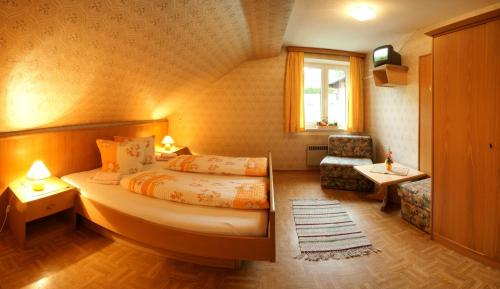 una camera d'albergo con letto e sedia di Gasthof Innerfraganterwirt a Flattach