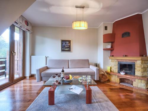 sala de estar con sofá y chimenea en VisitZakopane - Amber Apartment, en Zakopane