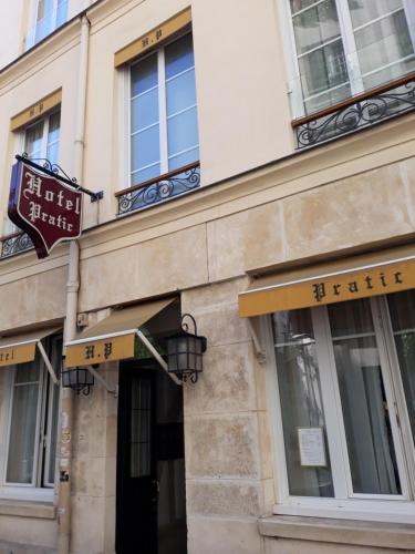 un edificio con letreros en el costado en Pratic Hotel en París