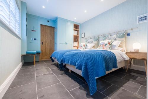 une chambre avec un lit aux murs bleus dans l'établissement Wella 5 Star Gold Award Luxury Cottage, à St Ives