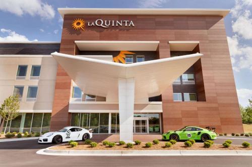 a hotel with two cars parked outside of it at La Quinta Inn & Suites by Wyndham Braselton in Braselton