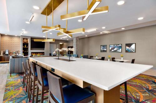 a lobby with a large white counter and chairs at La Quinta Inn & Suites by Wyndham Braselton in Braselton