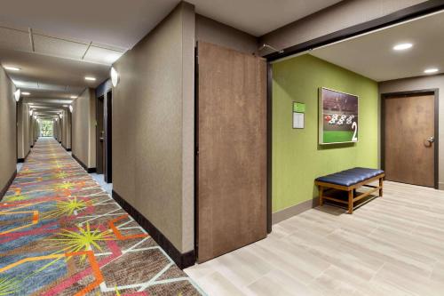 a hallway of an office with a bench on a colorful carpet at La Quinta Inn & Suites by Wyndham Braselton in Braselton