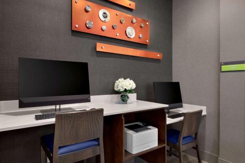 a computer desk with two monitors and two chairs at La Quinta Inn & Suites by Wyndham Braselton in Braselton